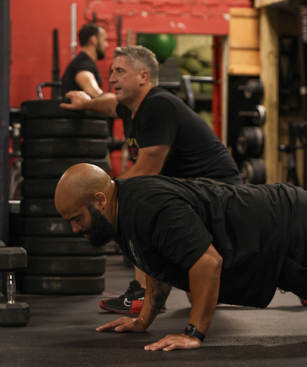 Two men pushing through push-ups side by side